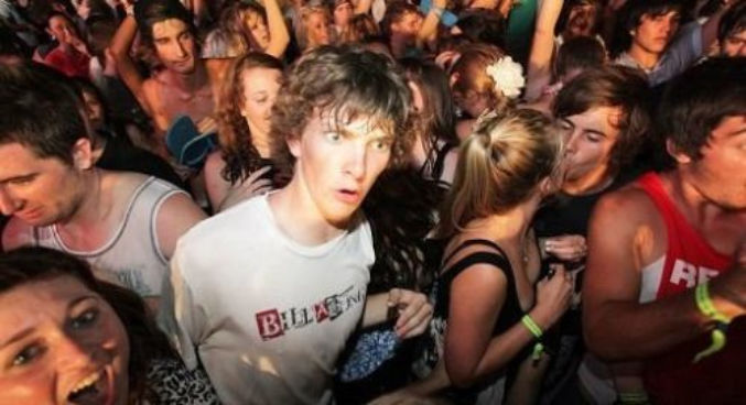 Meme picture 'sudden clarity Clarence': young man at a packed party/rave, staring into the distance as if he is having an epiphany